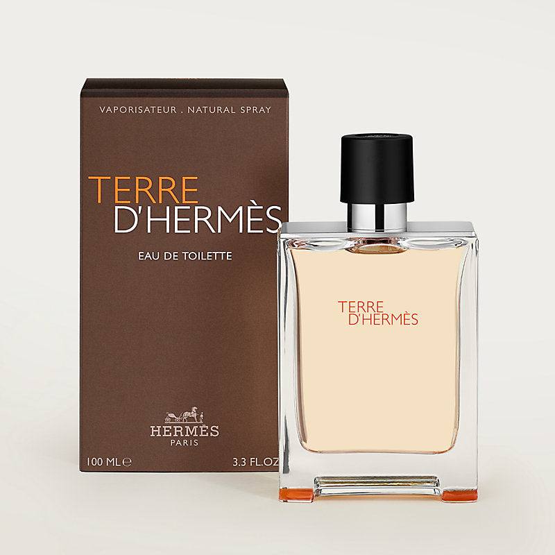 Hermès Terre d’Hermès eau de toilette in a clear glass bottle with amber fragrance, black cap and brown carton packaging.