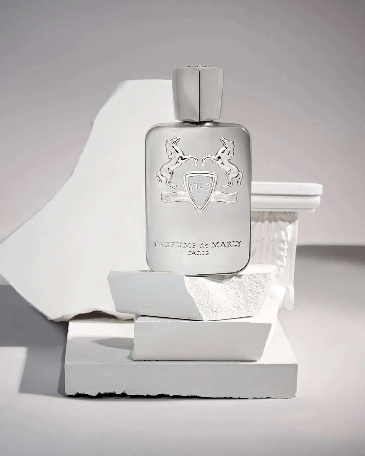 Parfum De Marly silver metallic rectangular perfume bottle with embossed horses and shield design on front